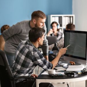 two men looking at computer screen in office